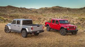 Image of two Jeep Gladiator trucks parked in a desert setting.