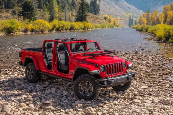 Image of a red 2020 Jeep Gladiator parked near a stream.