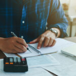 Customer working through financial information with a calculator.