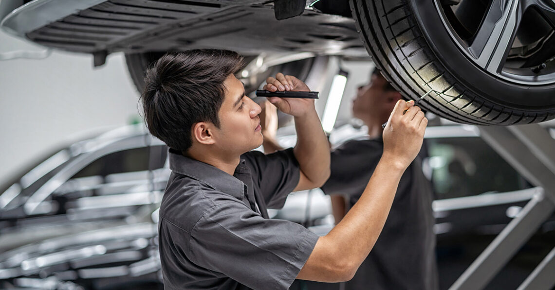 Jeep service technician inspecting tread depth